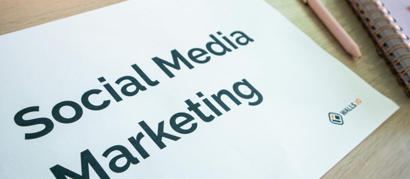 Close-up of a social media marketing document on a desk with a pen and notebook.