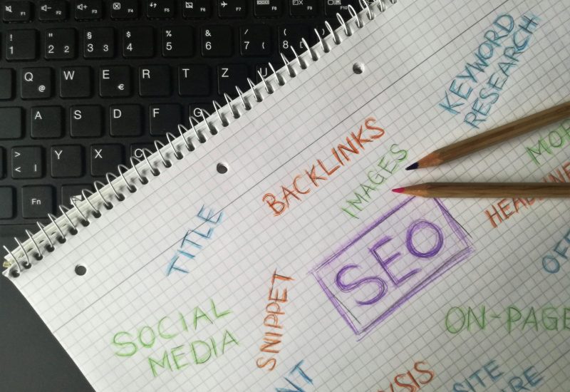Close-up of notebook with SEO terms and keywords, highlighting digital marketing strategy.